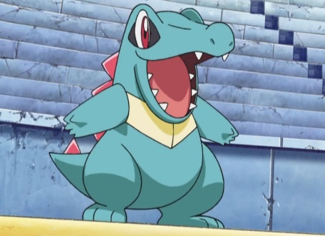 Totodile stands on its hind legs with its mouth open