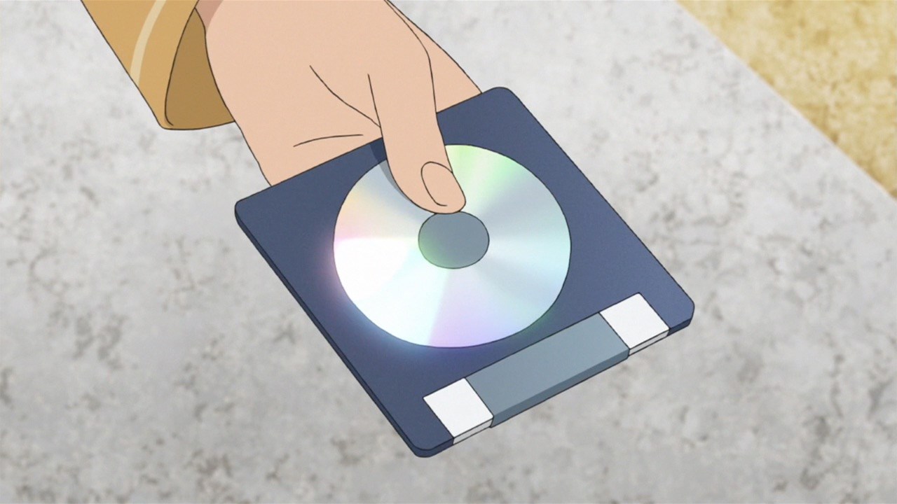 A hand holding what looks like a CD in Pokemon