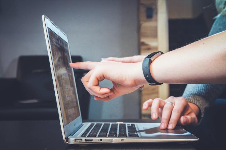 people pointing at laptop monitor