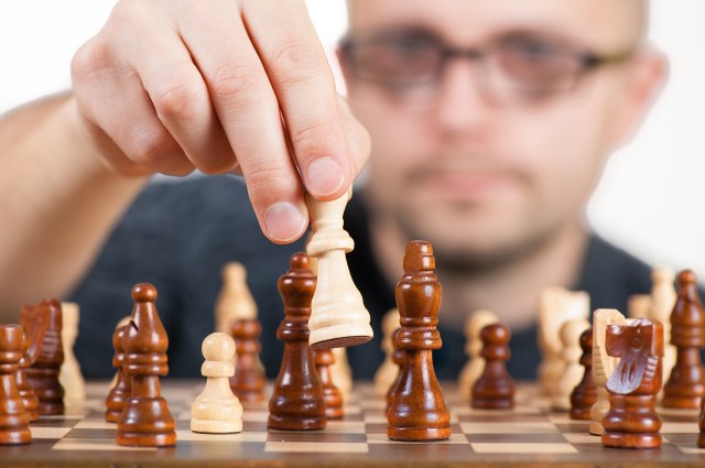 A man moves a chess piece