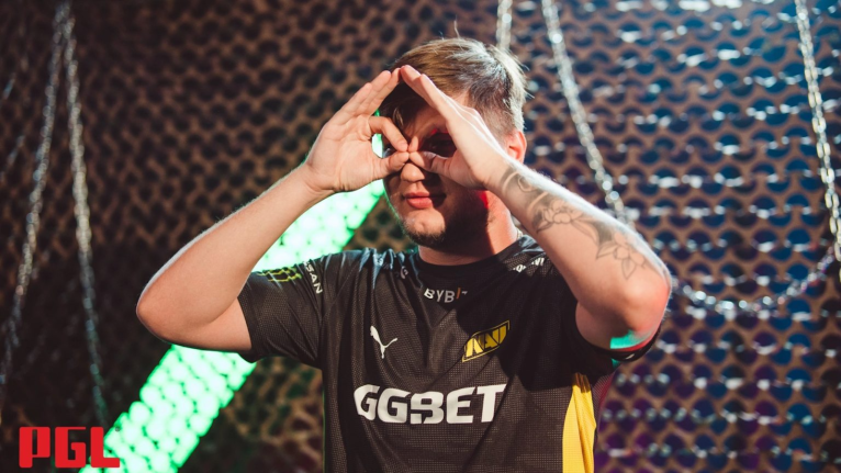 s1mple making a gesture with his hands while on stage.