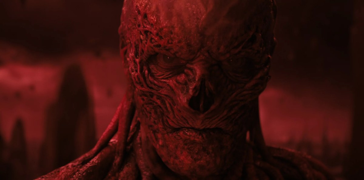 A screengrab from Stranger Things showing Vecna's scarred face looking into the camera