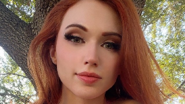 Amouranth stares into the camera in a park.