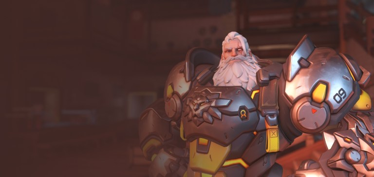 A man with a long white beard stands wearing a giant suit of armor, hands on hips in Overwatch 2.