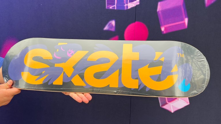 A skateboard with 'Skate' written on it is held up