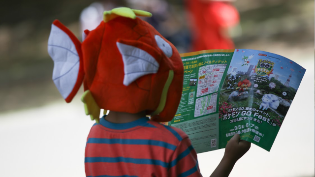 A young Pokemon fan looking at a pamphlet at Go Fest.