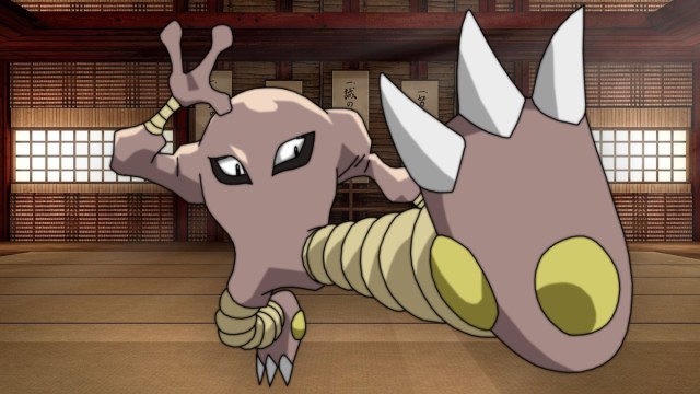 Hitmonlee doing a fly kick in a gym.