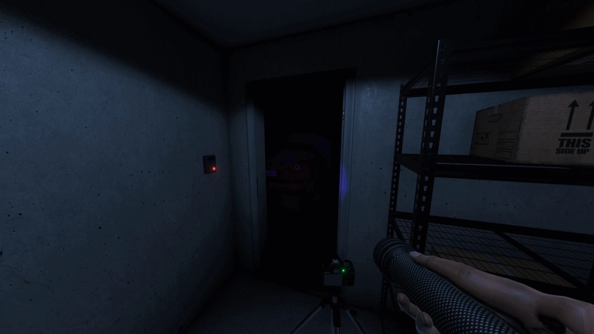 A Phasmophobia player holding up a flashlight in a dark room