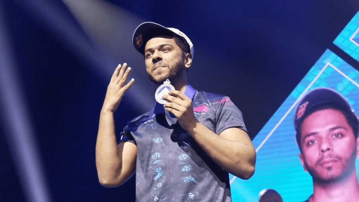 Arslan Ash holding up his Evo 2023 medal along with four fingers to count his championships.