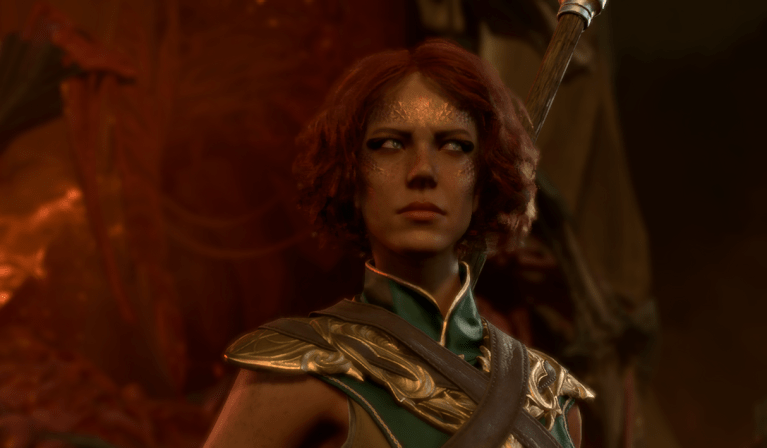 A Wood Half-Elf with short red hair, wearing a green and golden robe looks to the side