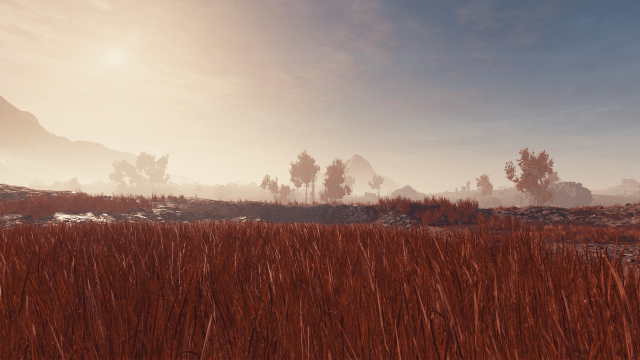 Image of red grass with mountains the background.