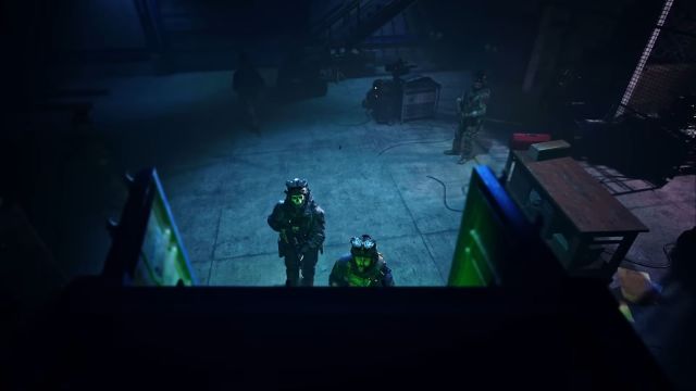 Image showcasing Ghost at shipping containers along with Captain Price. There is a visible blue light situated on the ground in the background.