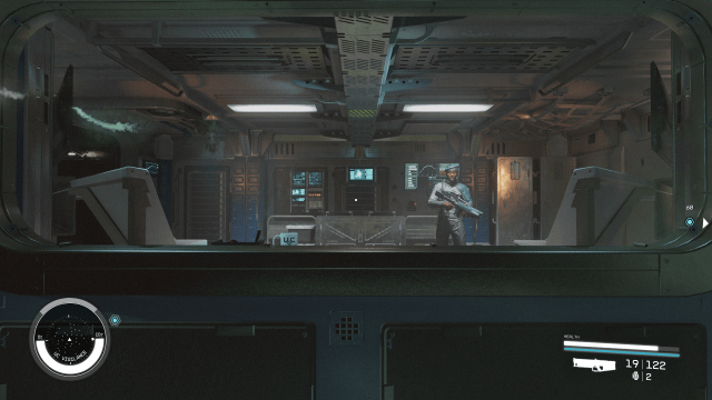 Image of the inside of a steel ship, standing in front of an armed soldier. 