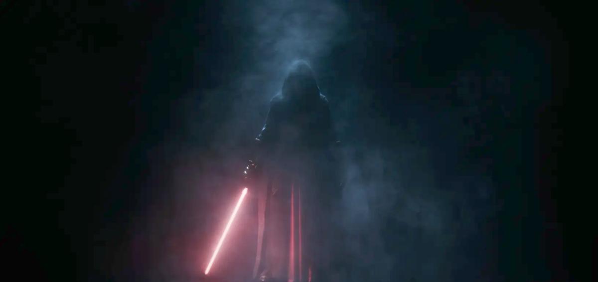 A shadowed figure in a cloak holding a red lightsaber in a promotional image for Star Wars: Knights of the Old Republic remake