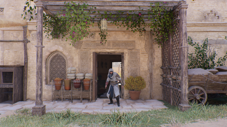 Image of a man in a white robe standing near a doorway.