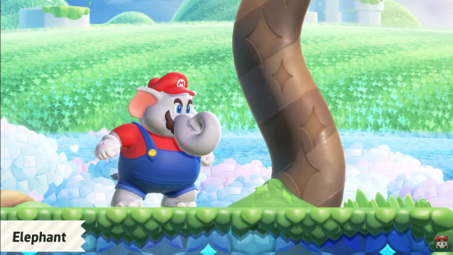 Elephant Mario walking on a grass course beside a tree.