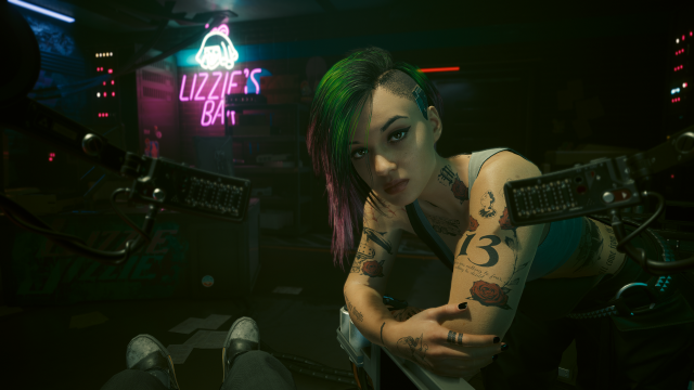 Judy leaning over V in the basement of Lizzie's Bar (Cyberpunk 2077).