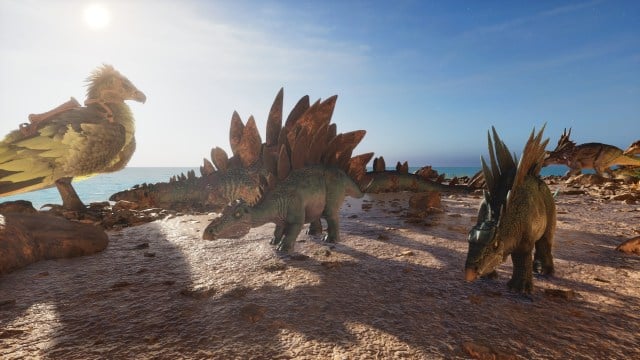 Two baby Stegosaurus in Ark: Survival Ascended stand in front of a dead Stegosaurus.