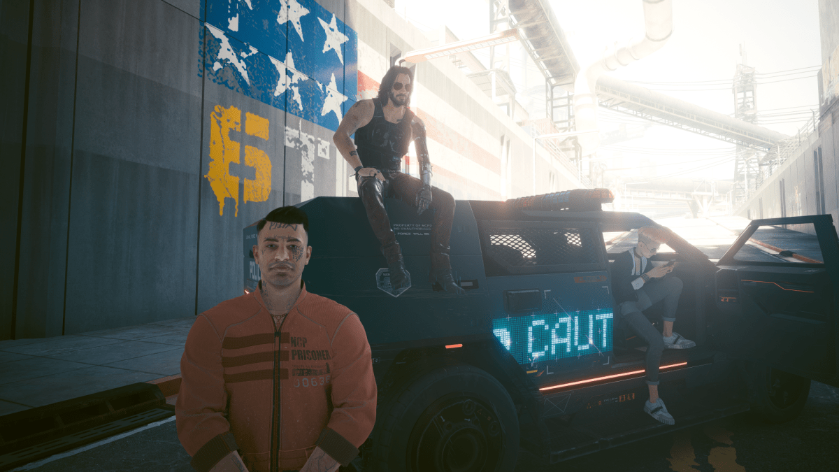 Joshua, a prisoner in an orange jumpsuit, standing in front of an NCPD cruiser in Cyberpunk 2077. Behind him, Johnny is sitting on top of the cruiser. It is a sunny day, but a bride is casting shadow on the scene.