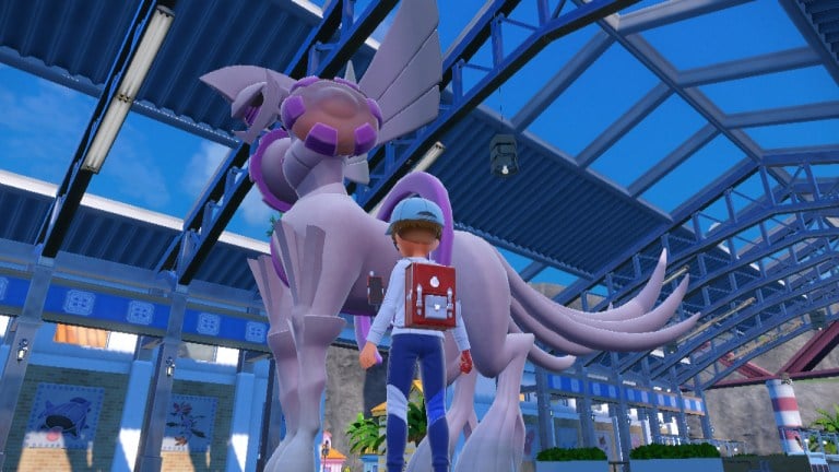 The Origin Forme of the Pokémon Palkia stands in an auction house in front of their trainer in Pokémon Scarlet and Violet.