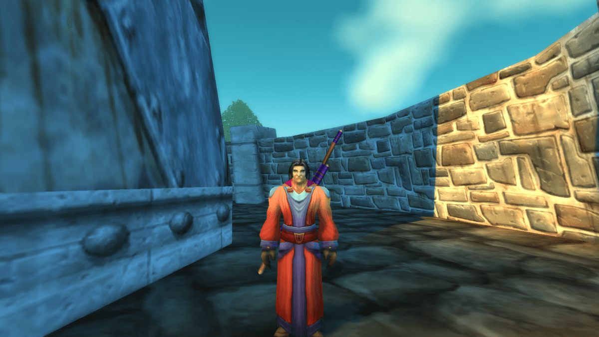 Image of a man in red and blue robes standing near a castle in WoW SoD.