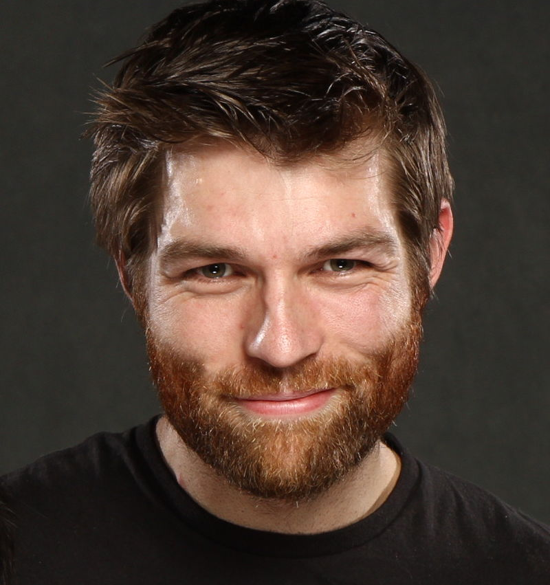 A portrait photo of Liam McIntyre smiling.