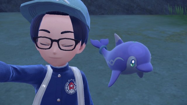 A player takes a photo with a shiny Palafin in Pokemon Scarlet and Violet.