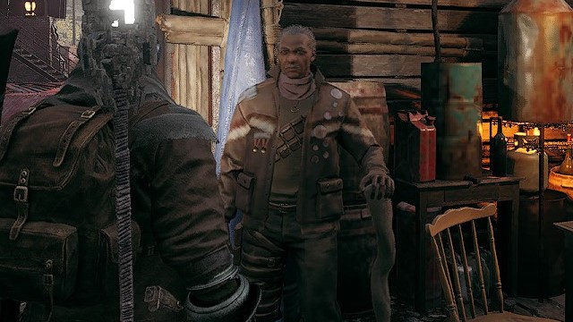 The character Reggie, a dark-faced man with ranger armor, stands in the scrapyard of Ward 13 in Remnant 2.
