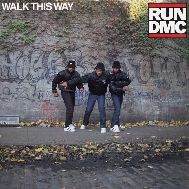 An image of the Walk This Way cover art from Fortnite Festival, which features three men in puffy jackets holding each other back from walking onto the street. 