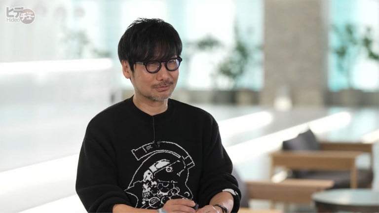 Hideo Kojima sits in a chair during a podcast.