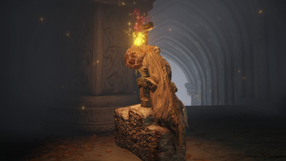 A man holds his head as a golden light emits from it in Elden Ring.