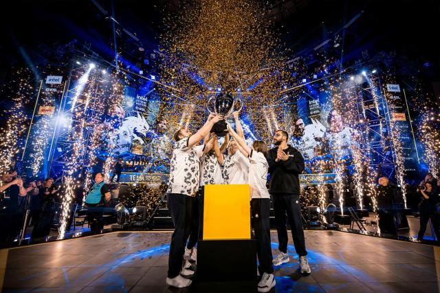 Team Spirit lifting the IEM Katowice 2024 trophy aloft  on stage.