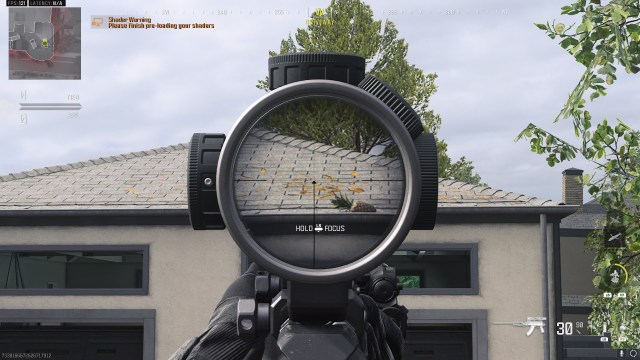 A CoD player aiming down the scope of the gun, looking at a garage roof that used to have a pizza on it.