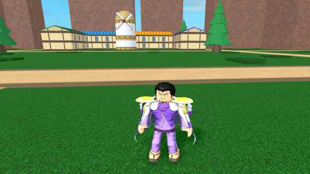 A character stands in a grass lawn outside a house in Blox Fruits.