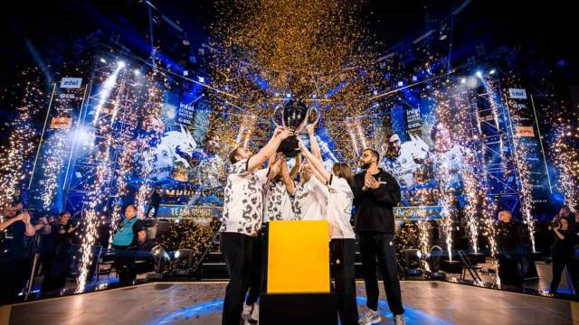 Team Spirit's CS2 team lift the IEM Katowice trophy as the crowd celebrates.