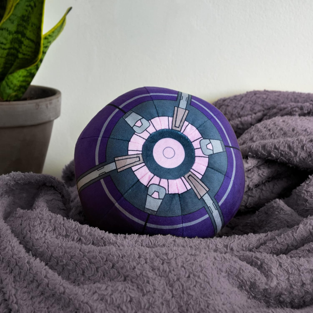 The Destiny 2 Numskull Servitor Plush on a blanket.