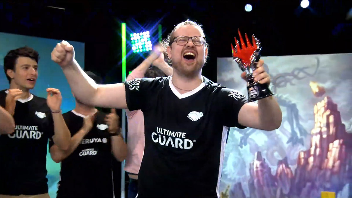 Simon Nielsen celebrates after winning MTG Pro Tour Amsterdam 2024, holding the trophy.