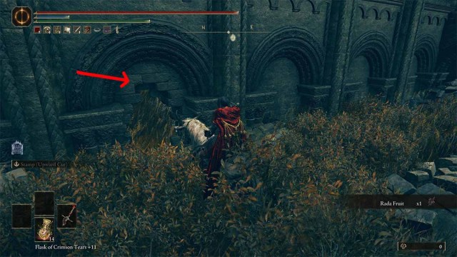 Back entrance to Temple Town Ruins in Elden Ring DLC with red arrow pointing to hole in the wall