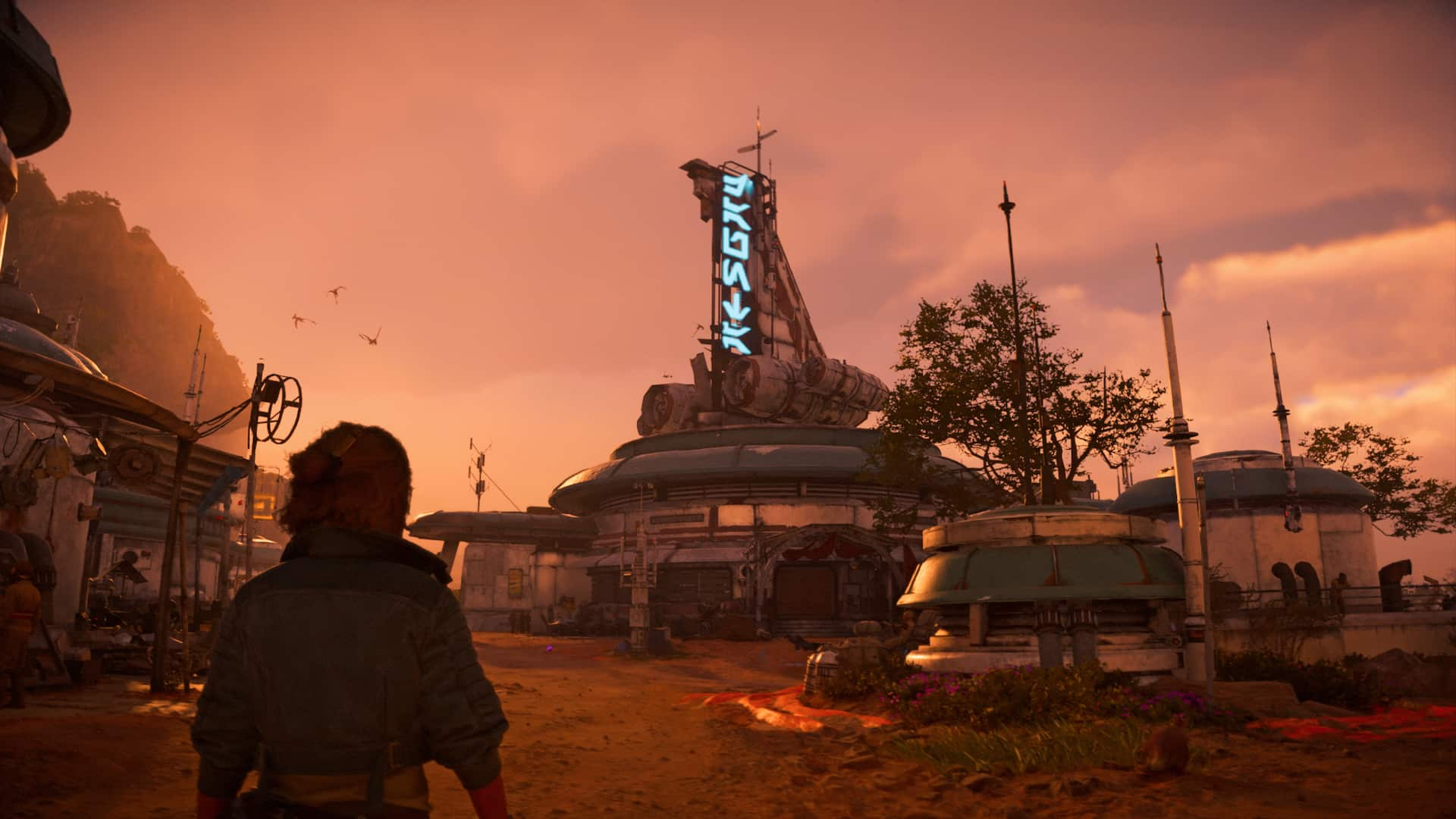 Kay Vess looks up at a cantina sign in a neon blue script as the sun sets over a nearby mountain.