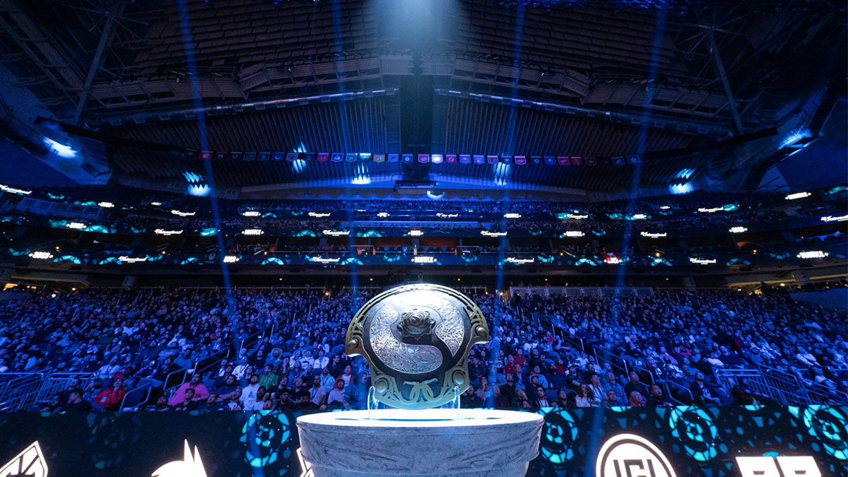 The Aegis of Champions sits on a plinth and lit by a spotlight in the Climate Pledge Arena during TI 2023.