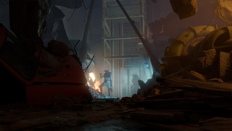 A player stands at the bottom of a destroyed mine in Half-Life: Alyx, dimly lit by a small torch and fire.