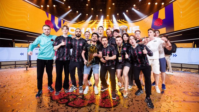 Twisted Minds' PUBG team and staff stand celebrating on-stage after winning the PGS 4 trophy.