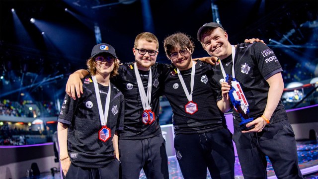 The G2 Stride Rocket League team stand shoulder-to-shoulder wearing medals and lifting the RLCS London Major trophy.