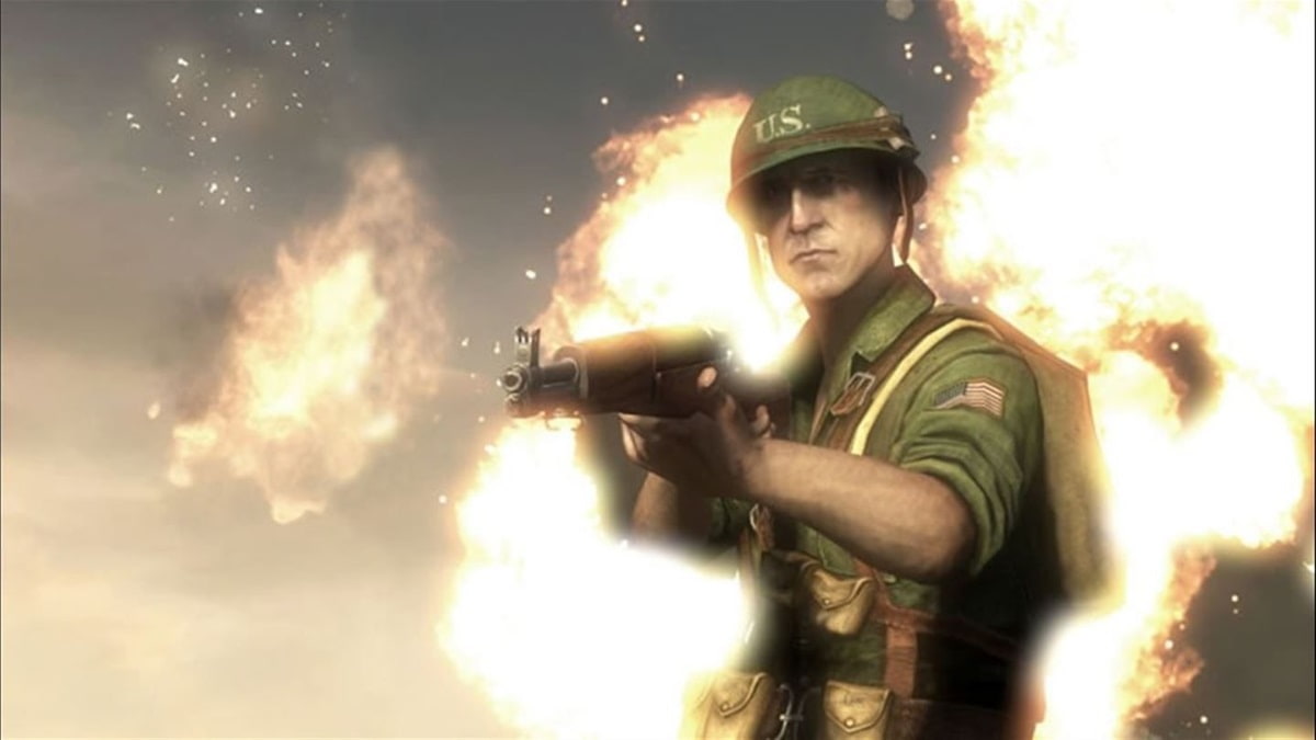 A US soldier pointing his gun at the player character with an explosion in the background in Battlefield 1943