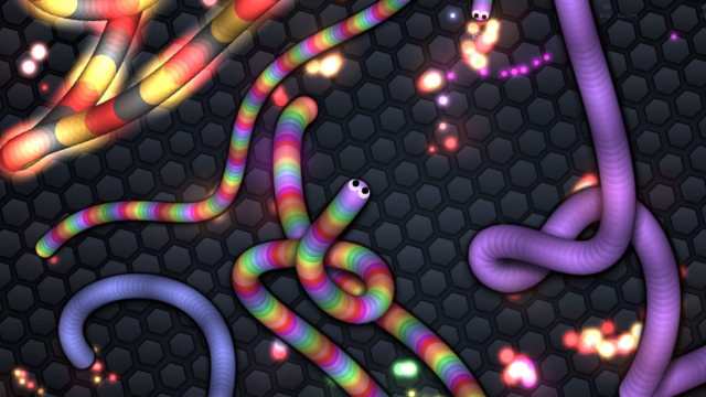 Slither.io game screen showing three multi-colored snakes eating energy balls