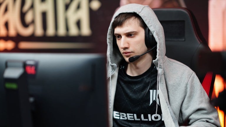 Arteezy sits at his PC at PGL Wallachia Season 1 while wearing a grey hoodie.