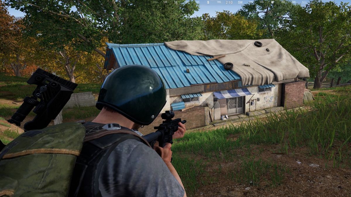 A player in PUBG pointing his gun toward a building with the Secret Room