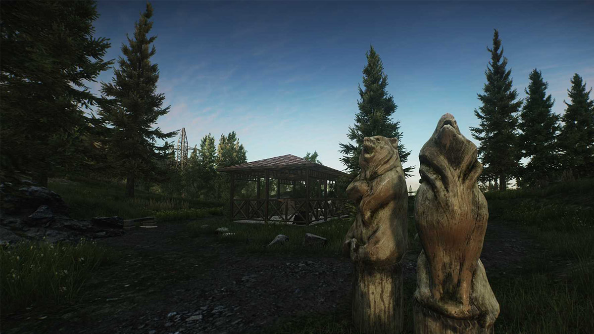 Two bear and wolf statues stand next to a gazebo in a forest in Escape from Tarkov.