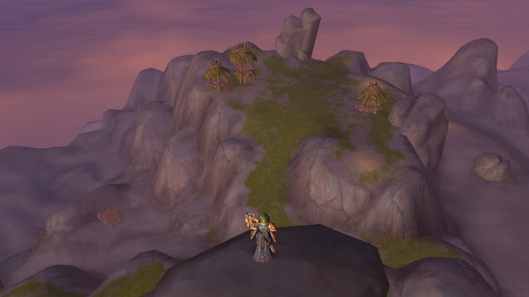 A Player standing on a tall rock overlooking one of the three shields islands in the isle of dorn in wow