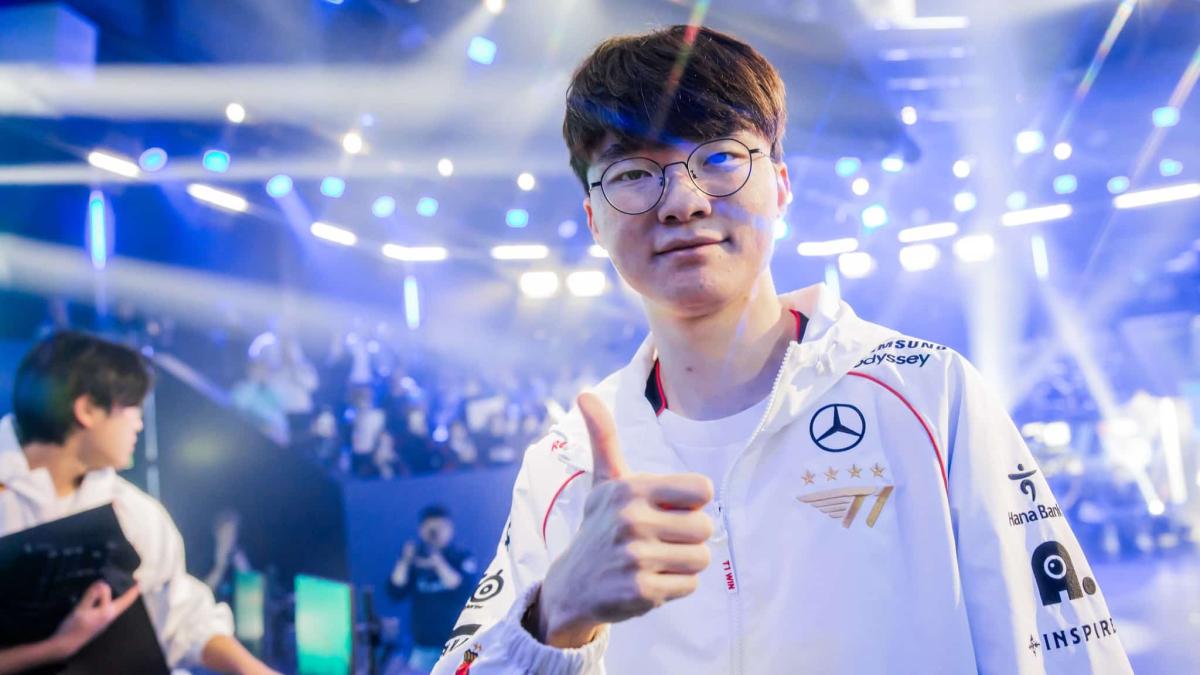 Faker gives a thumbs up to the camera with crowds of people and lights flashing behind him